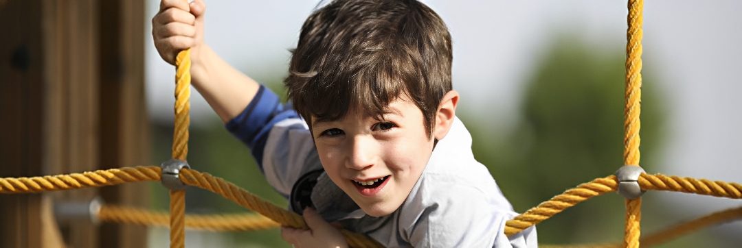 Child climbing a rope ladder outdoors