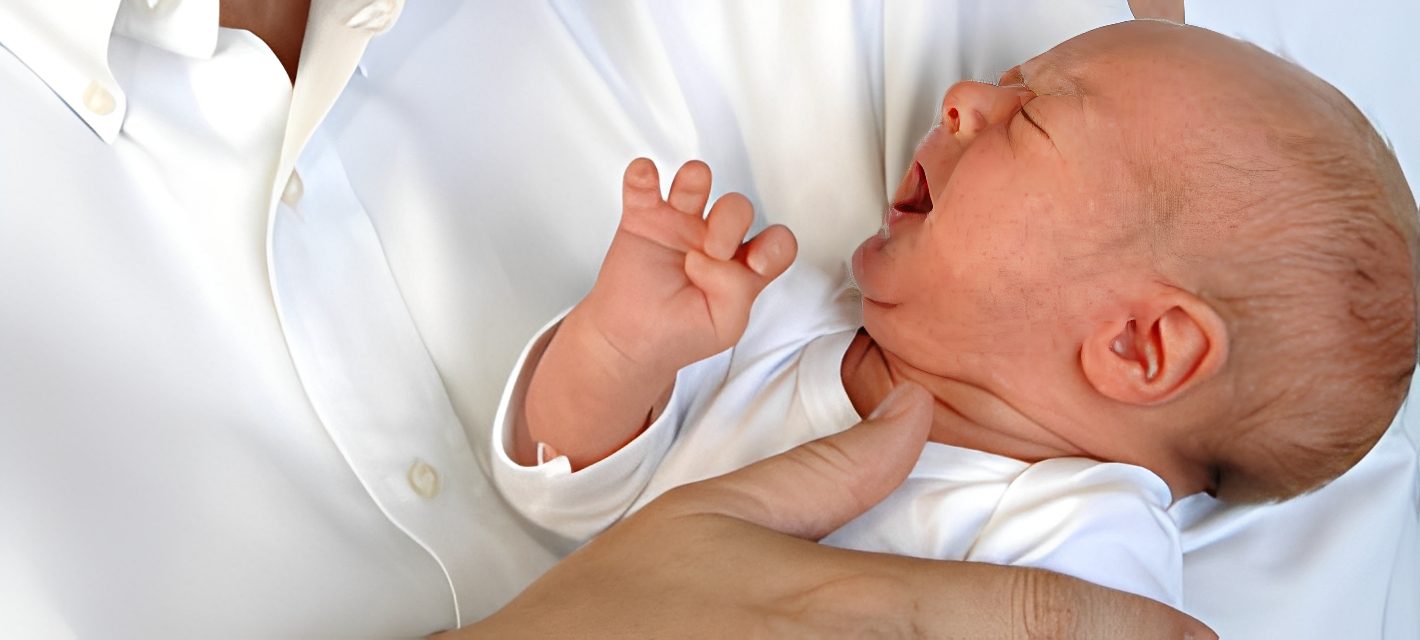 Infant in white outfit crying